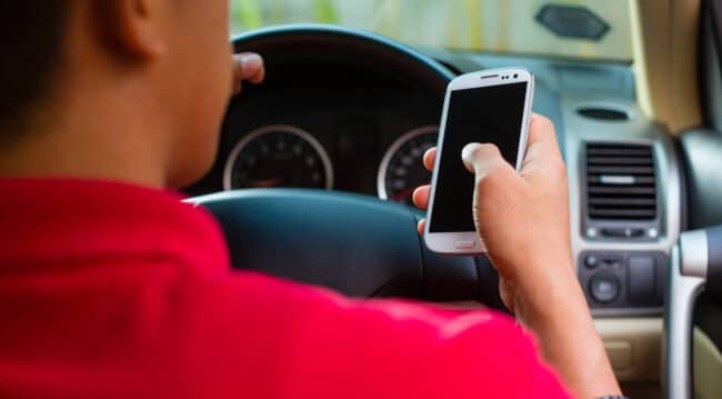man driving while on phone