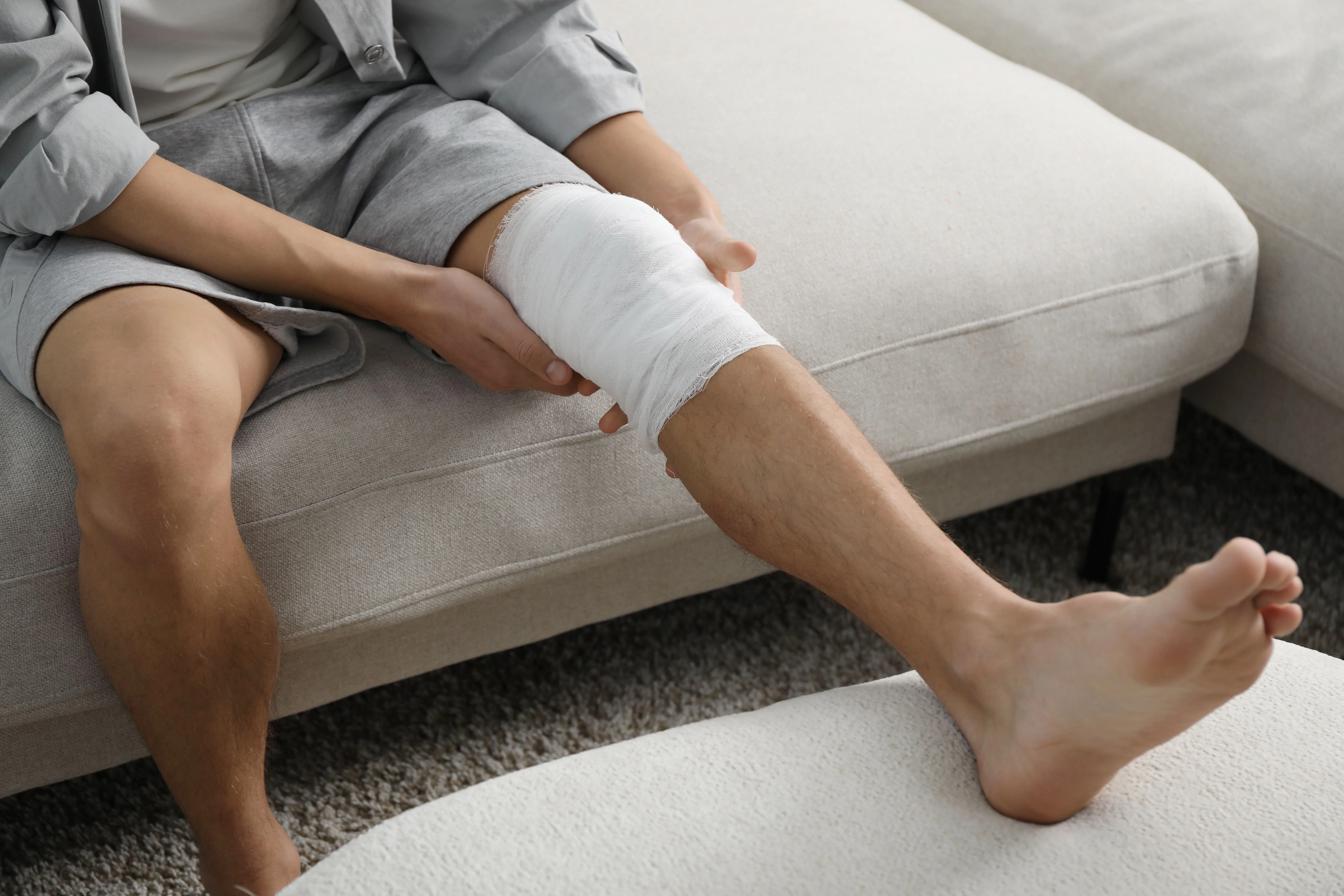 Person recovering at home with a bandaged knee after a soft tissue injury, illustrating the impact of a Florida accident and the right to seek compensation for injury-related damages.